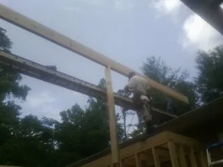 Carpenter setting a ridge beam over a new addition frame — Ice Dam Removal by Roofing Brothers in Zearing