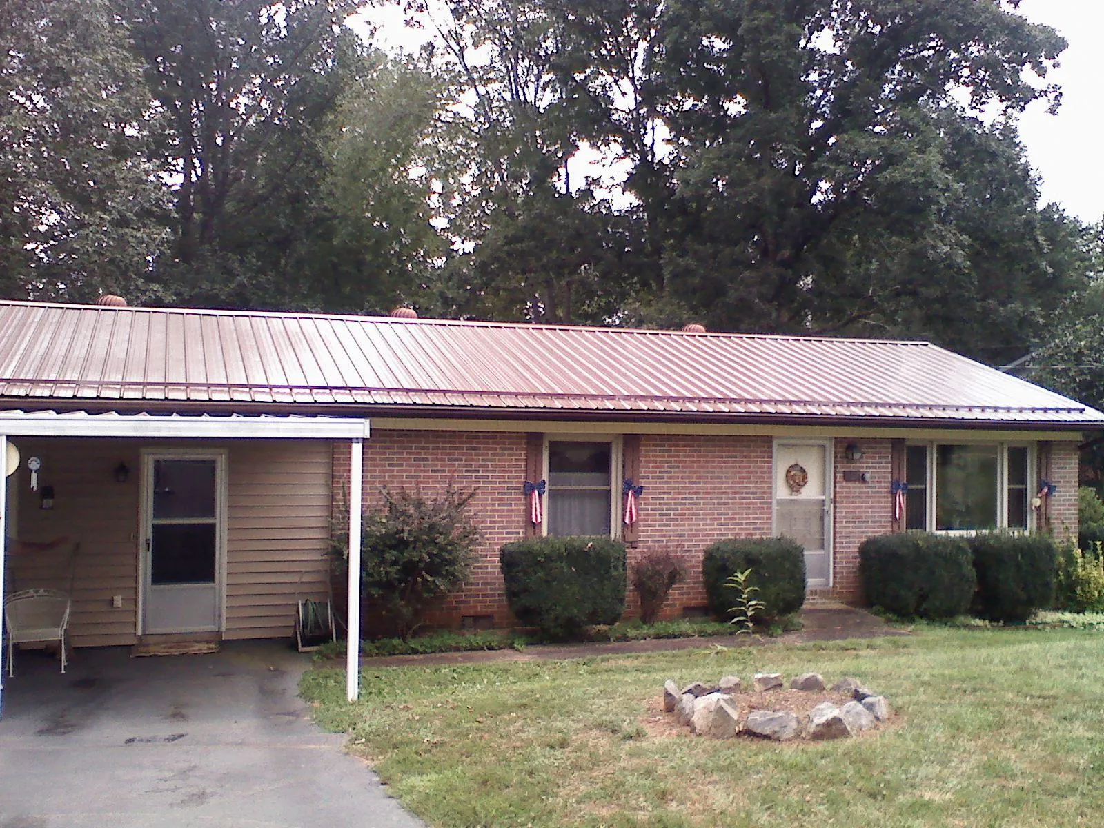 Bronze metal roof and carport on a brick ranch home — Roof Repair work by our crew in Zearing