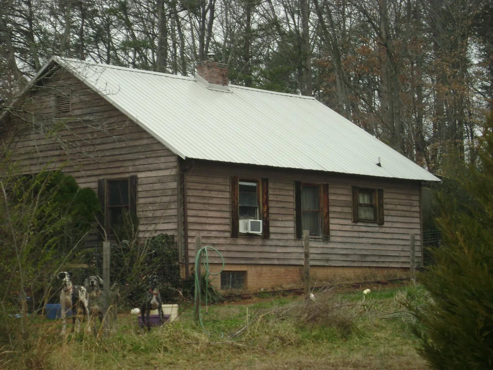 White metal roof on an old wood sided farmhouse, from a Metal Roof Installation job in Zearing